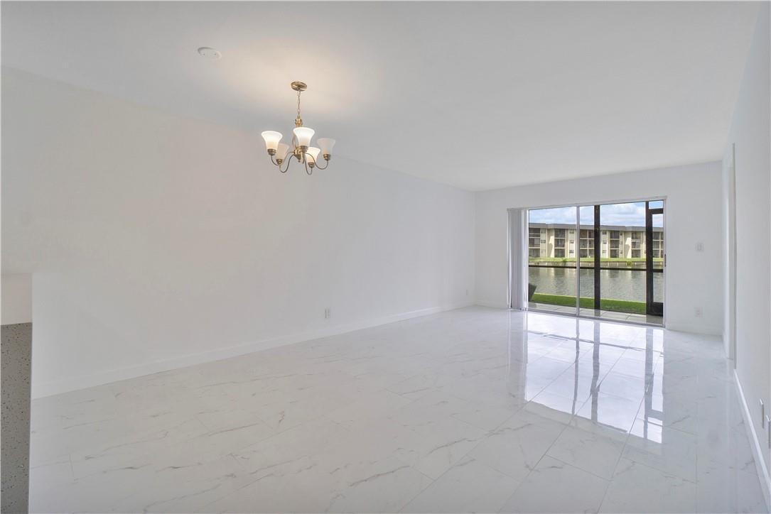 8025 South Colony Circle, Unit 106 Tamarac, FL 33321 - Photo 3 of 14 wooden floor in an empty room with a window