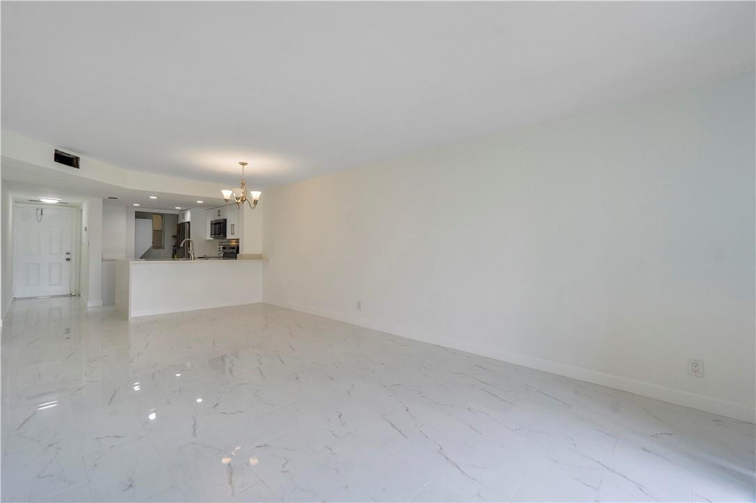 8025 South Colony Circle, Unit 106 Tamarac, FL 33321 - Photo 5 of 14 a view of a kitchen with a sink and a refrigerator