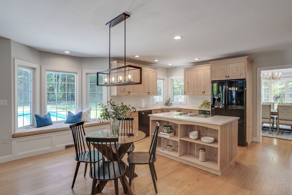 35 Buehler Road Bedford, MA 01730 - Photo 3 of 41 a kitchen with a dining table chairs and white cabinets