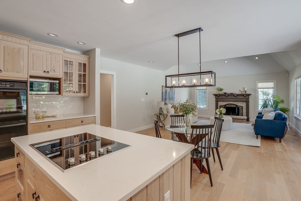 35 Buehler Road Bedford, MA 01730 - Photo 6 of 41 a kitchen with a stove a kitchen island a dining table and chairs