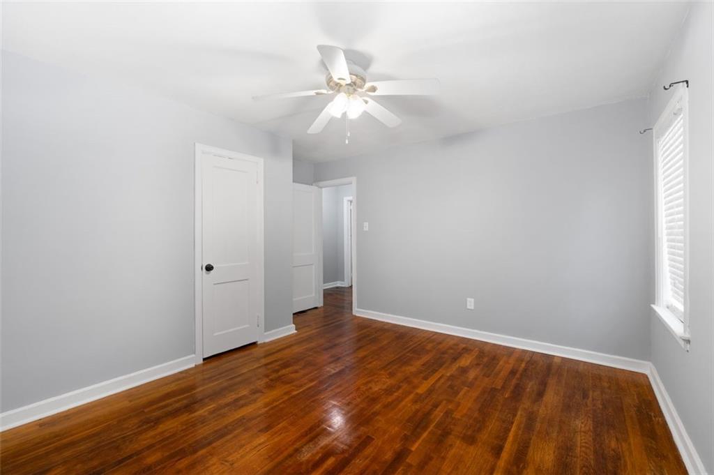 111 Poplar Street Fairburn, GA 30213 - Photo 19 of 32 a view of an empty room with wooden floor and a window