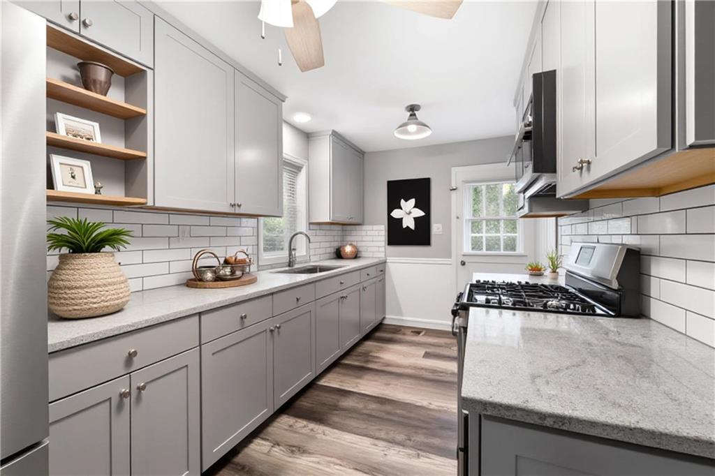 111 Poplar Street Fairburn, GA 30213 - Photo 20 of 32 a kitchen with granite countertop a sink a stove and cabinets