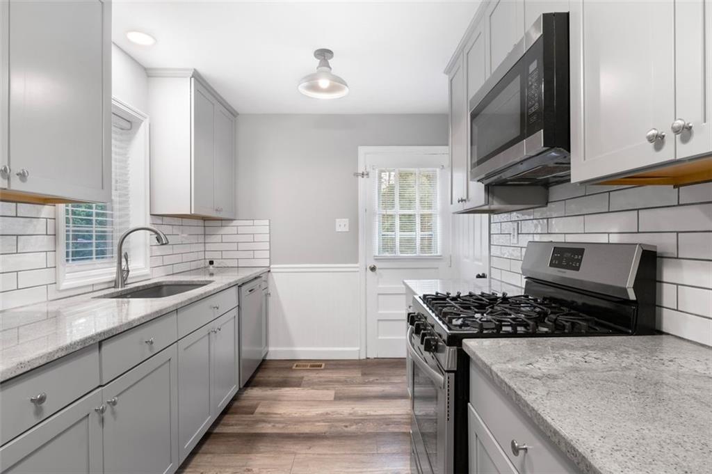 111 Poplar Street Fairburn, GA 30213 - Photo 22 of 32 a kitchen with a sink stove and cabinets