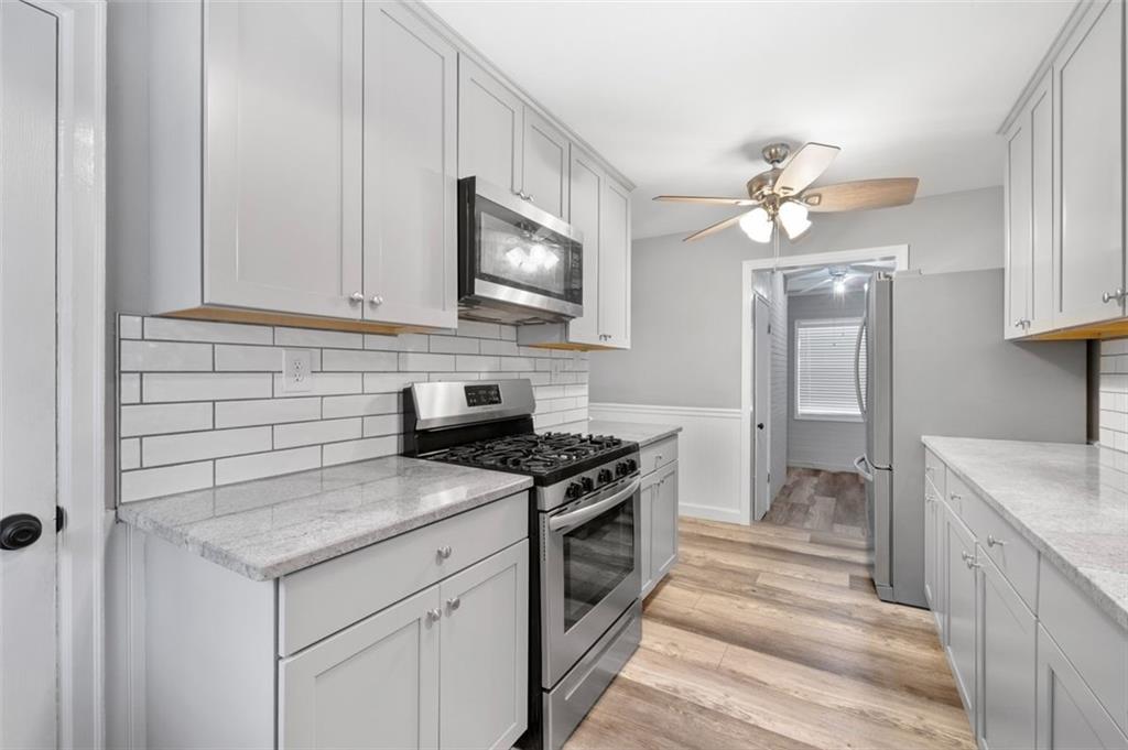 111 Poplar Street Fairburn, GA 30213 - Photo 23 of 32 a kitchen with a stove sink and cabinets