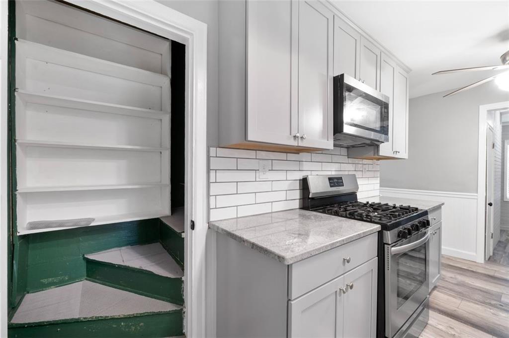 111 Poplar Street Fairburn, GA 30213 - Photo 26 of 32 a kitchen with a stove microwave and sink