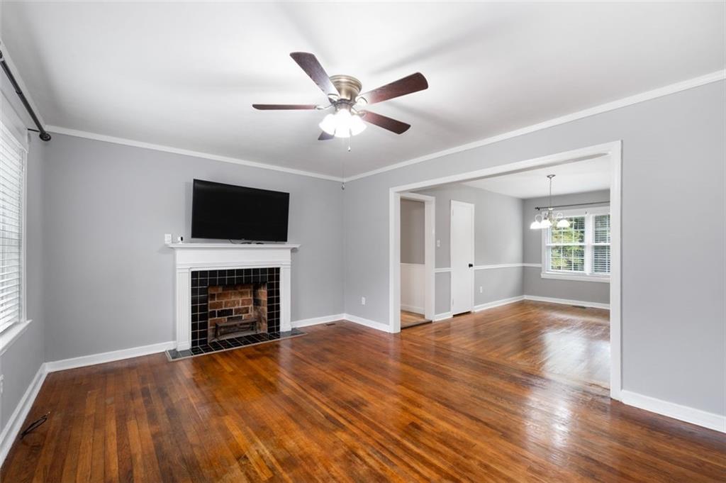 111 Poplar Street Fairburn, GA 30213 - Photo 7 of 32 a view of empty room with wooden floor fireplace and a window