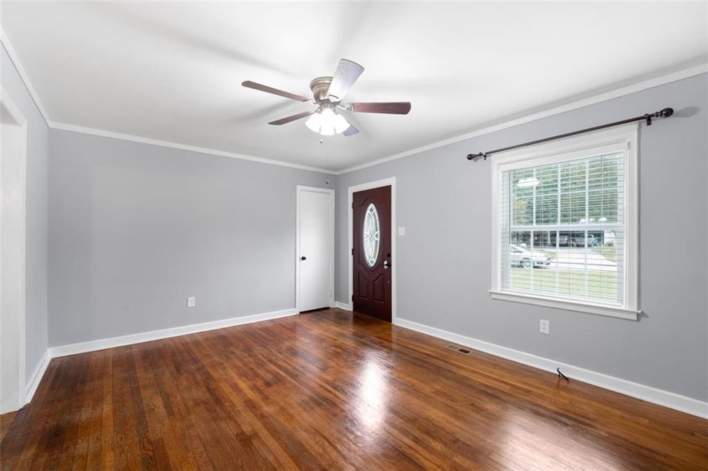 111 Poplar Street Fairburn, GA 30213 - Photo 9 of 32 a view of an empty room with wooden floor and a window