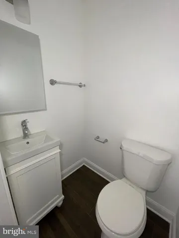a white toilet sitting next to a sink and vanity
