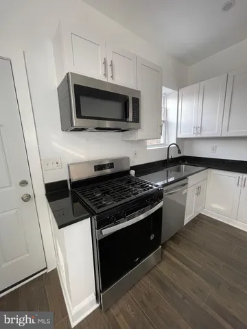 a kitchen with stainless steel appliances kitchen island granite countertop a stove a sink and a microwave