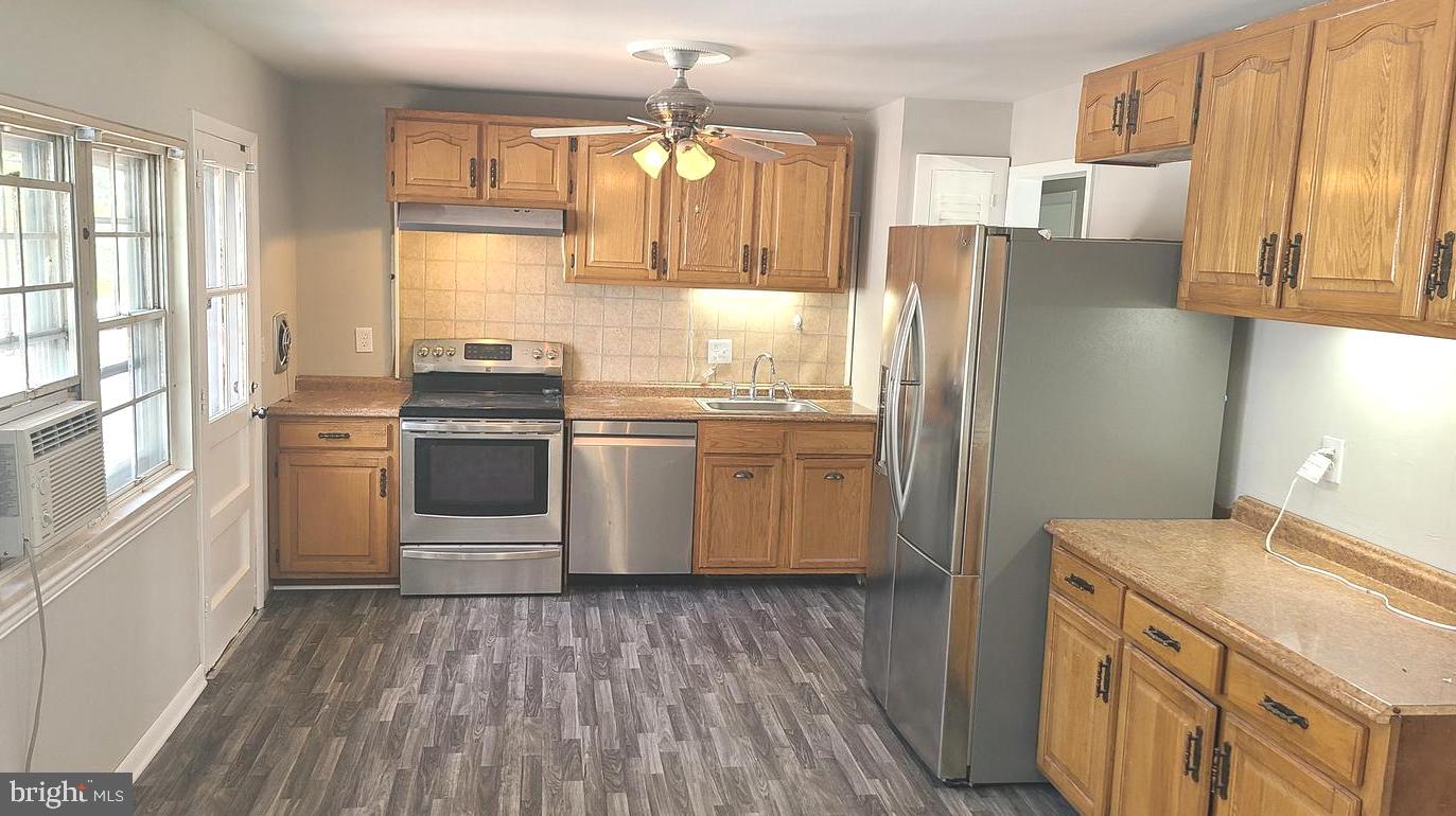 26 Alwyn Road Newark, DE 19713 - Photo 6 of 24 a kitchen with stainless steel appliances granite countertop a refrigerator a sink dishwasher a stove and white countertops with wooden floor