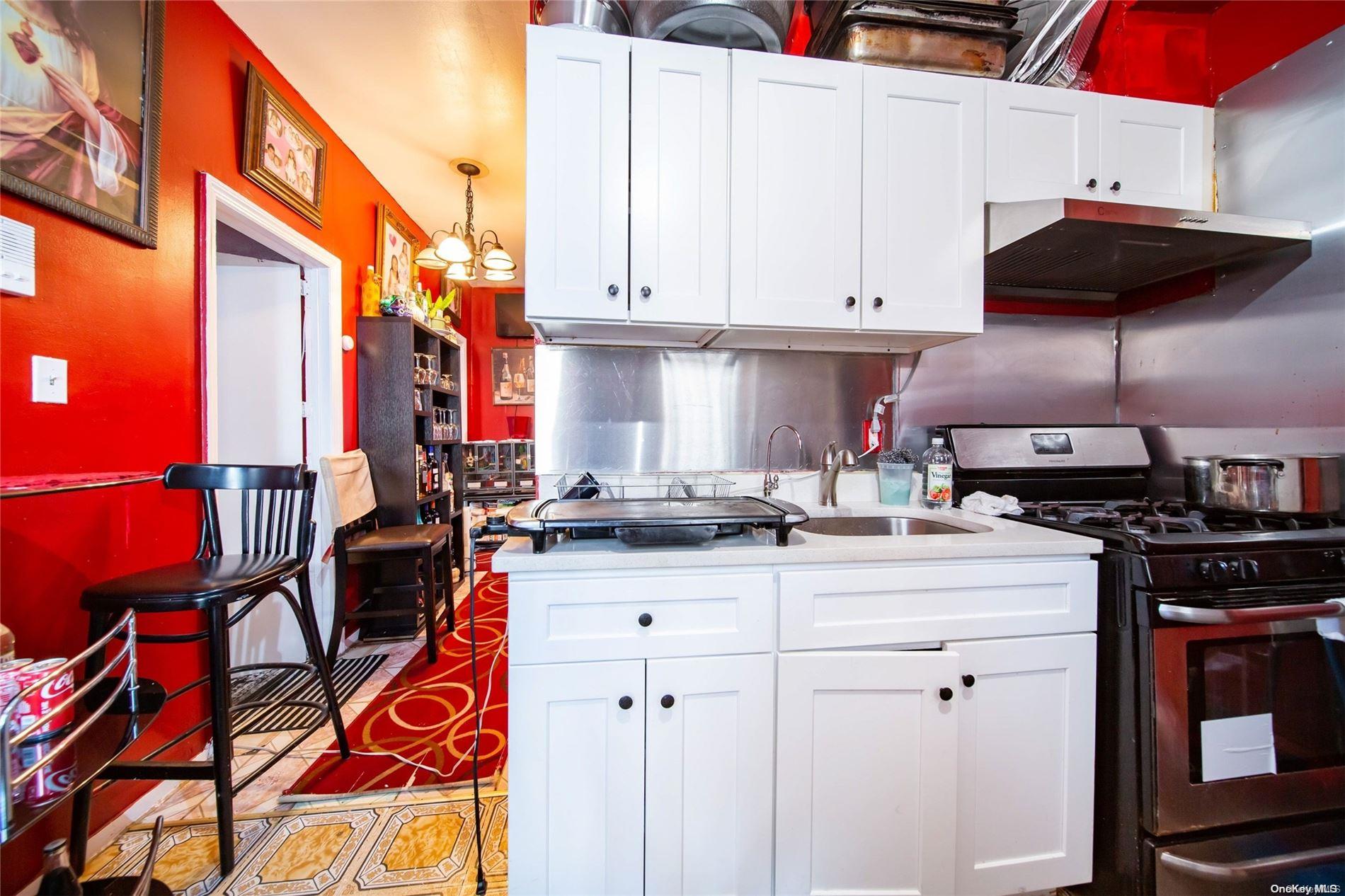 102-18 37th Avenue Queens, NY 11368 - Photo 7 of 12 a kitchen with stainless steel appliances granite countertop a stove a sink and a cabinets