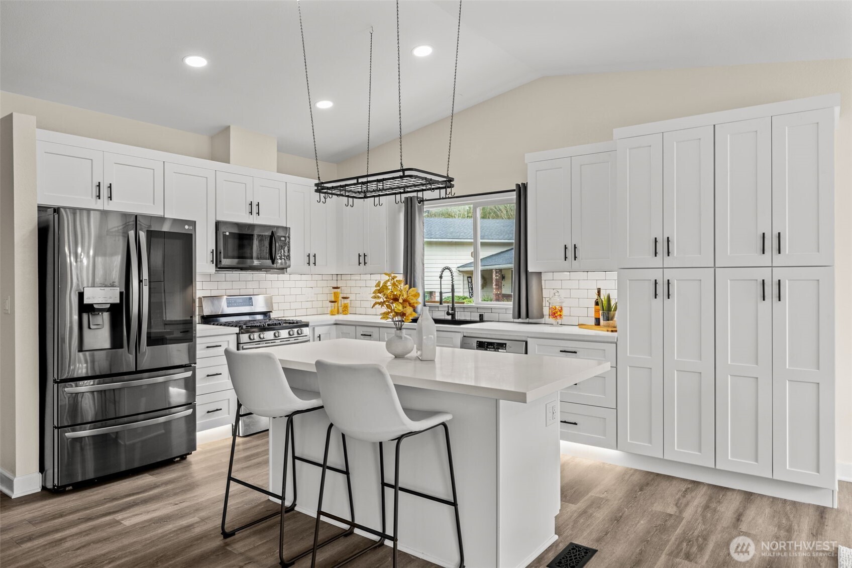 4115 105th Place Southeast Everett, WA 98208 - Photo 11 of 39 a kitchen with stainless steel appliances a refrigerator a stove a sink dishwasher and white cabinets with wooden floor