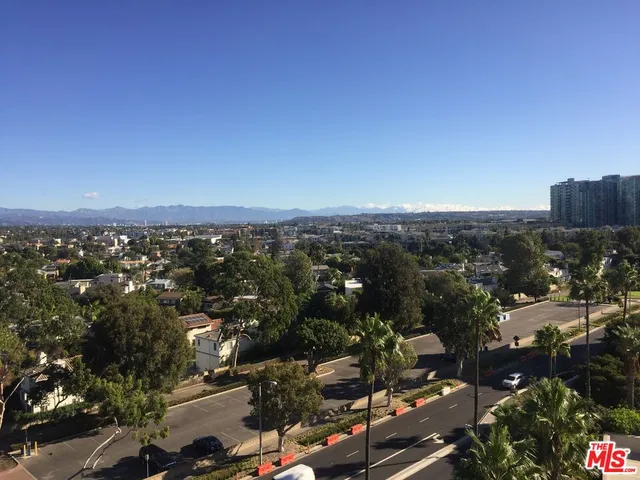 a view of an empty room with wooden floor and windows