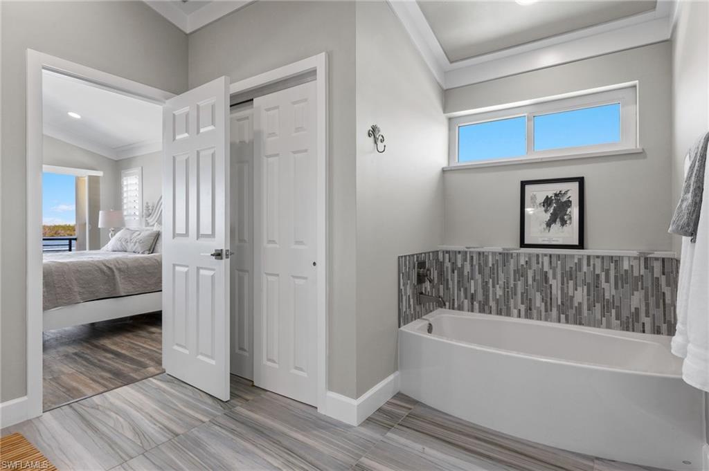 21521 Madera Road Fort Myers Beach, FL 33931 - Photo 28 of 45 a bathroom with a bathtub and a walk in closet