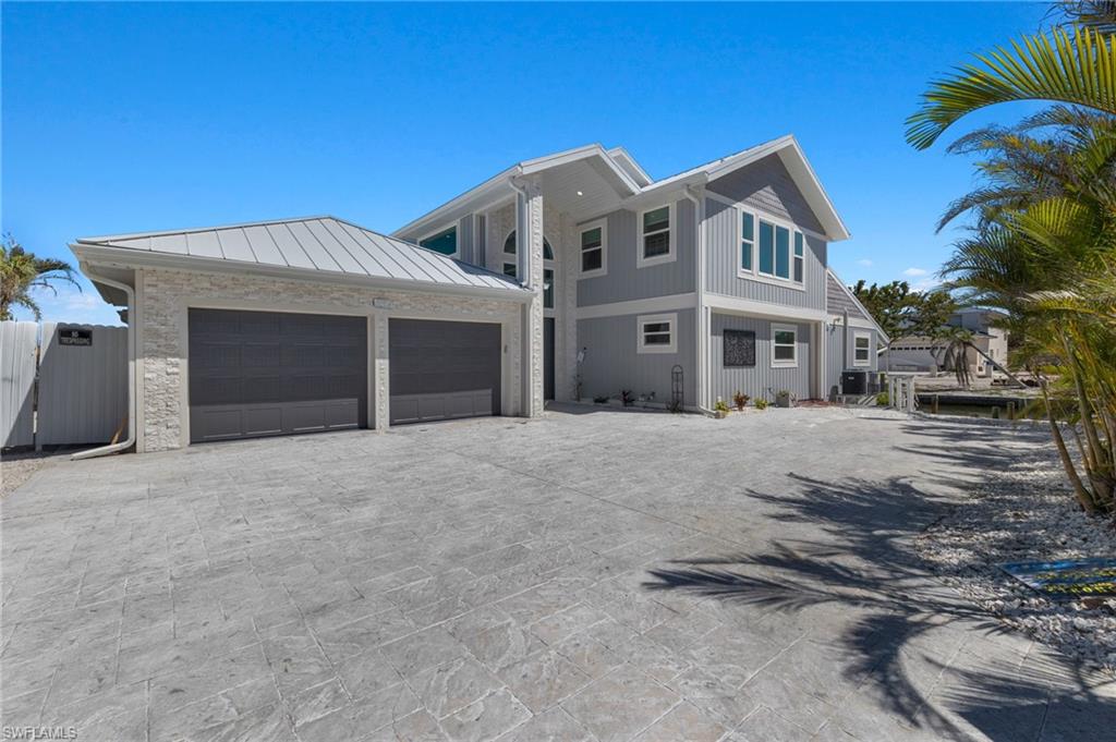 21521 Madera Road Fort Myers Beach, FL 33931 - Photo 44 of 45 a front view of a house with a yard and garage