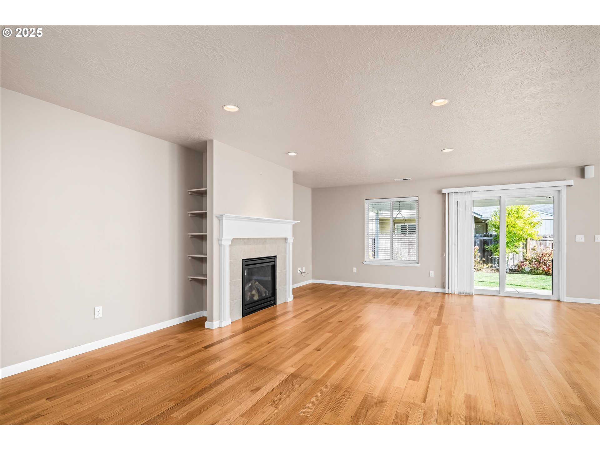 1176 Unity Drive Junction City, OR 97448 - Photo 12 of 44 a view of empty room with wooden floor and fireplace