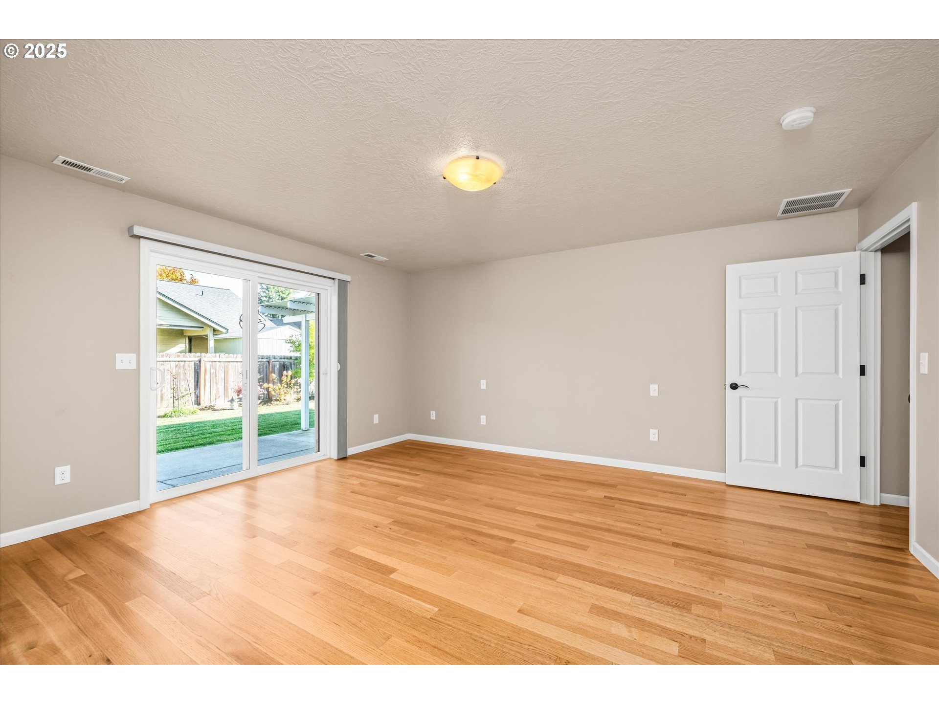 1176 Unity Drive Junction City, OR 97448 - Photo 19 of 44 a view of an empty room with wooden floor and a window