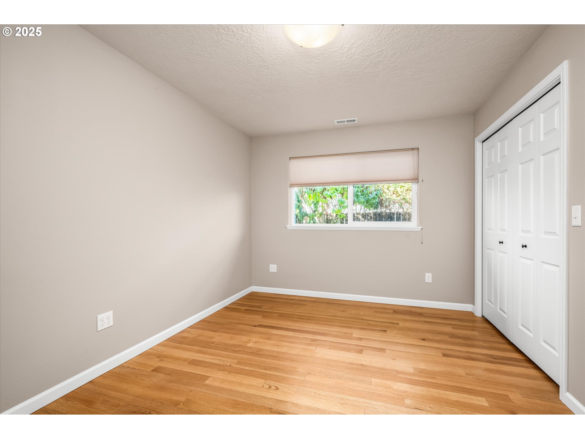 1176 Unity Drive Junction City, OR 97448 - Photo 26 of 44 an empty room with wooden floor and windows