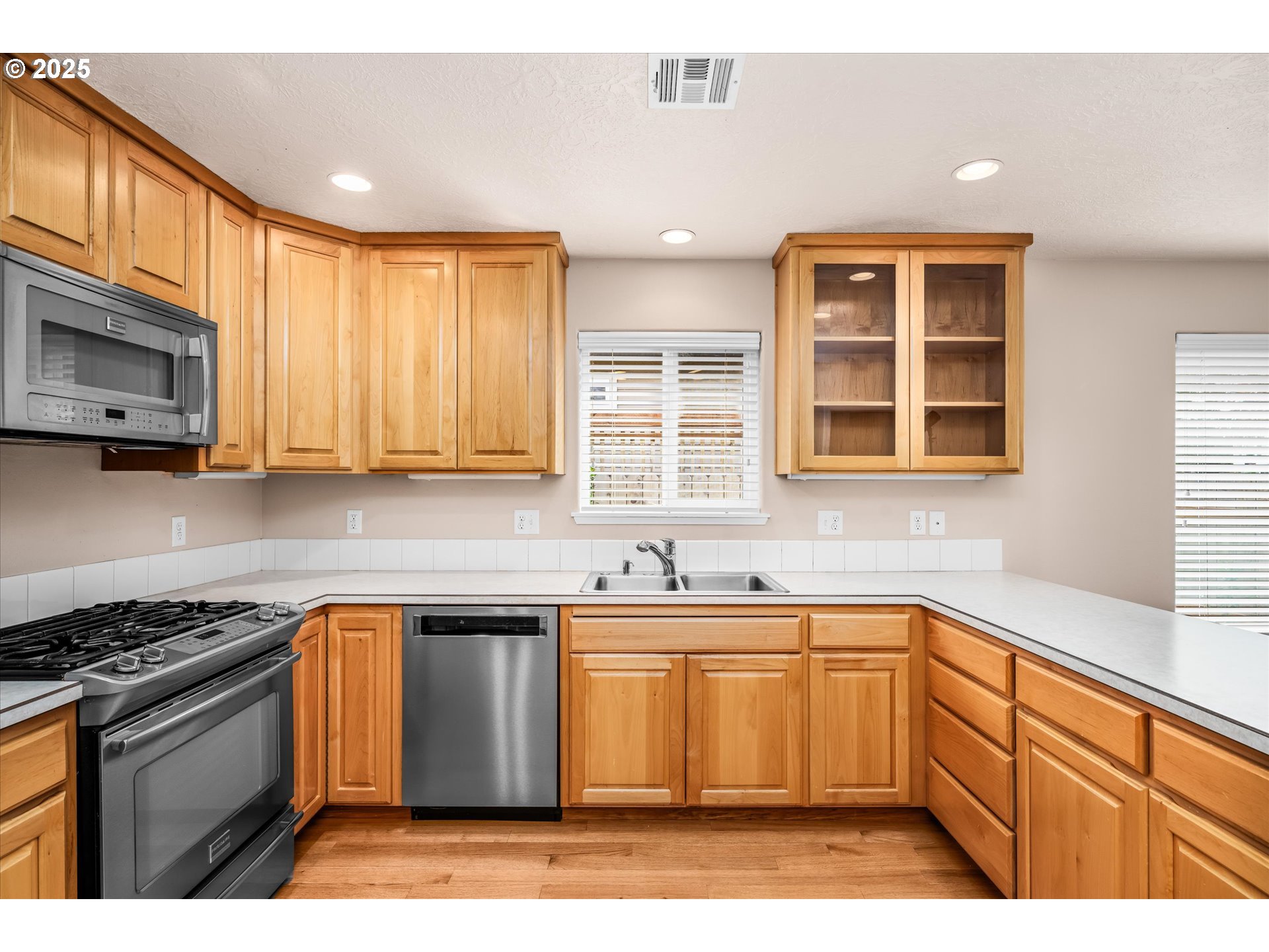 1176 Unity Drive Junction City, OR 97448 - Photo 8 of 44 a kitchen with stainless steel appliances granite countertop a sink a stove a microwave cabinets and a window