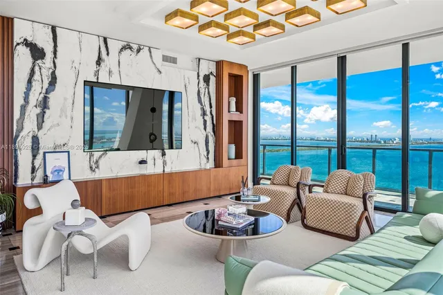 a dining room with furniture water view and a floor to ceiling window