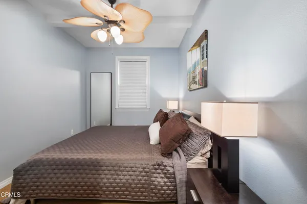 a bedroom with a bed and a lamp on dresser