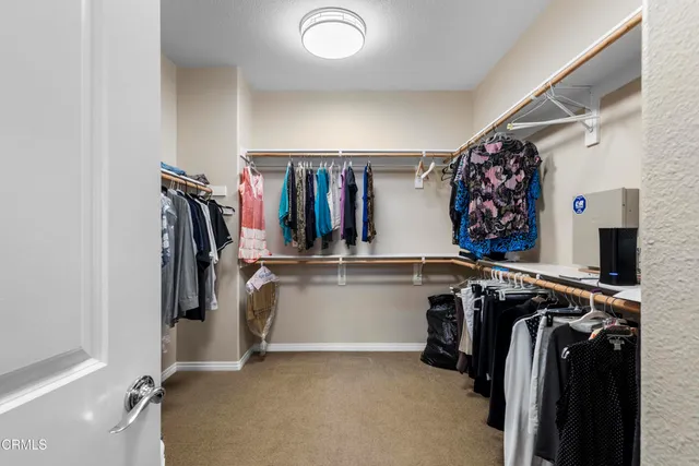 a view of walk in closet with clothes and shoes