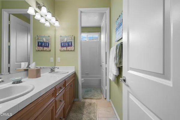 a bathroom with a double vanity sink mirror and a bathtub