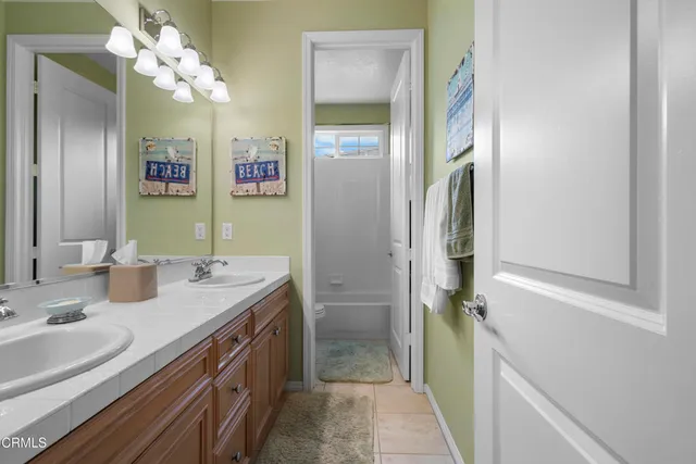 a bathroom with a double vanity sink mirror and a bathtub