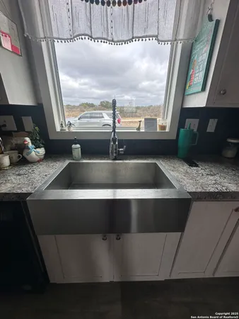 a kitchen with a sink a counter top space and cabinets