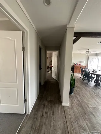 a view of a hallway view with living room and wooden floor