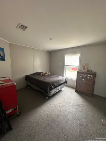 a spacious bedroom with a bed and window