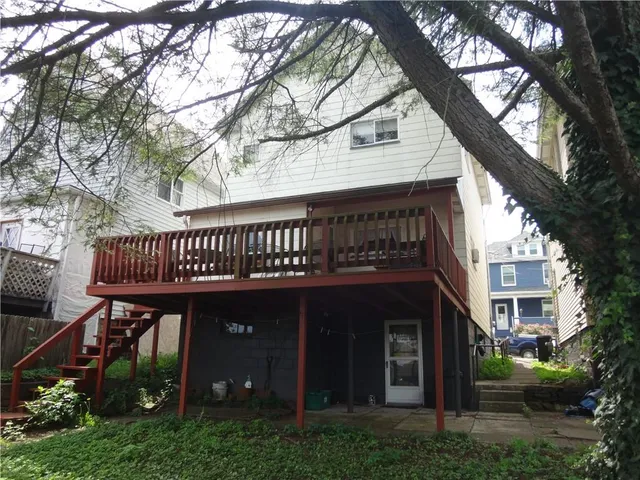 a view of a street with potted plants and large trees