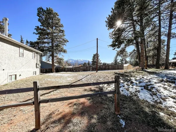 a view of a yard with wooden fence