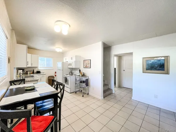 a living room with furniture a rug and kitchen view
