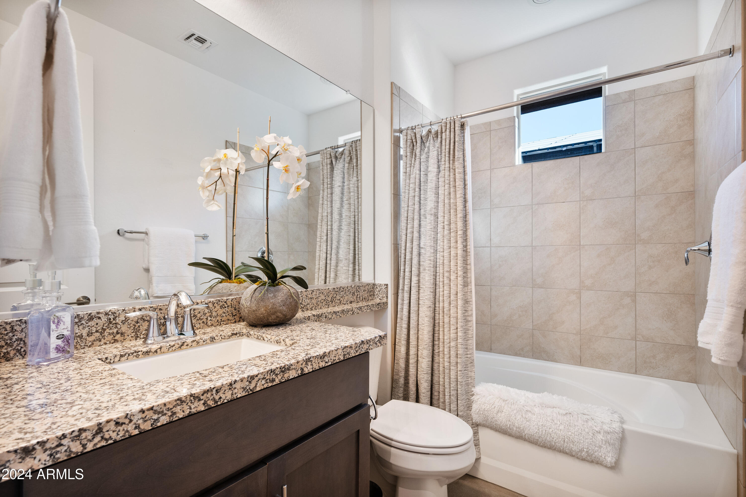 17910 East Cindercone Road Rio Verde, AZ 85263 - Photo 34 of 38 a bathroom with a granite countertop sink a mirror a bathtub and shower