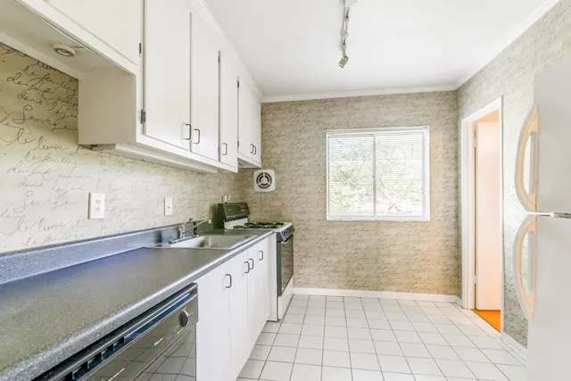 a kitchen with a sink a stove and cabinets