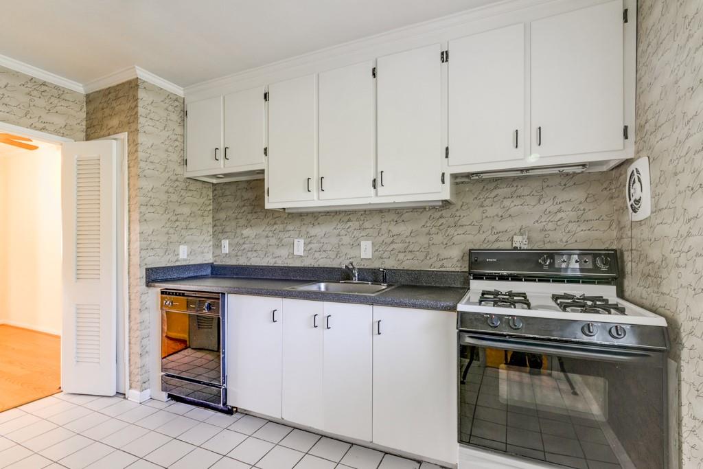 91 Rumson Road Northeast, Unit C35 Atlanta, GA 30305 - Photo 5 of 12 a kitchen with granite countertop a stove sink and cabinets
