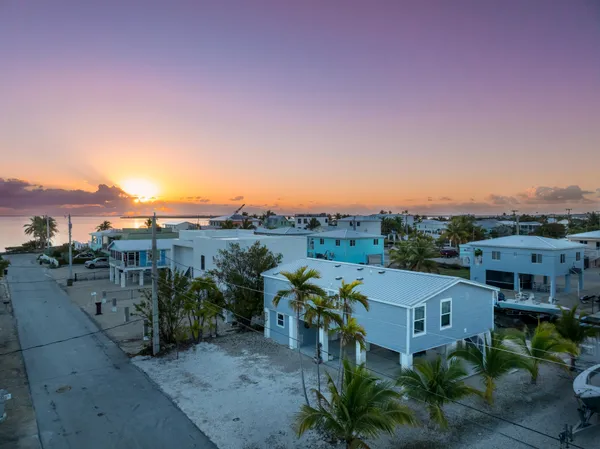 a view of a house with a yard and table under an umbrella