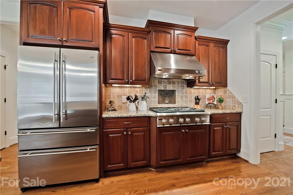 145 Huntington Ridge Place Mooresville, NC 28115 - Photo 16 of 45 a kitchen with granite countertop stainless steel appliances and wooden cabinets