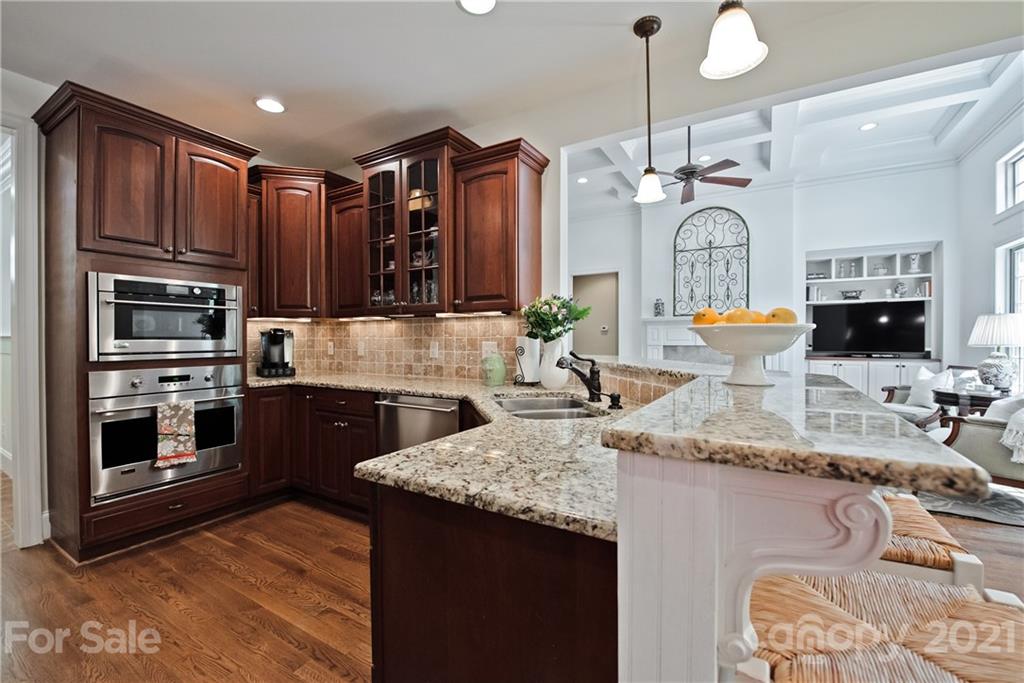 145 Huntington Ridge Place Mooresville, NC 28115 - Photo 17 of 45 a kitchen with stainless steel appliances granite countertop a sink a stove and a wooden cabinets