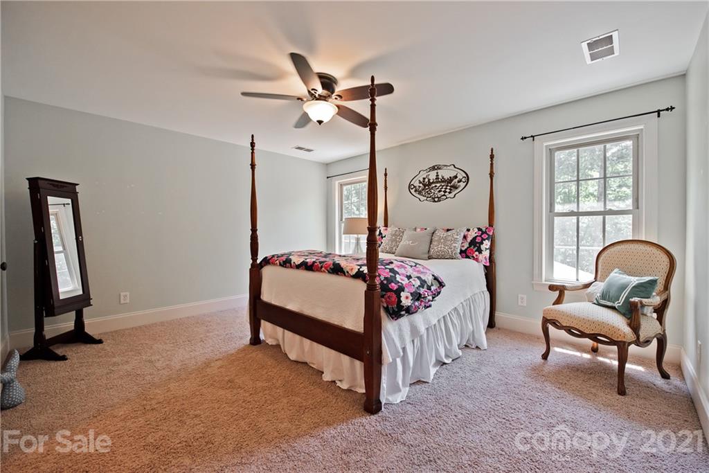 145 Huntington Ridge Place Mooresville, NC 28115 - Photo 30 of 45 a bedroom with a bed and a chandelier
