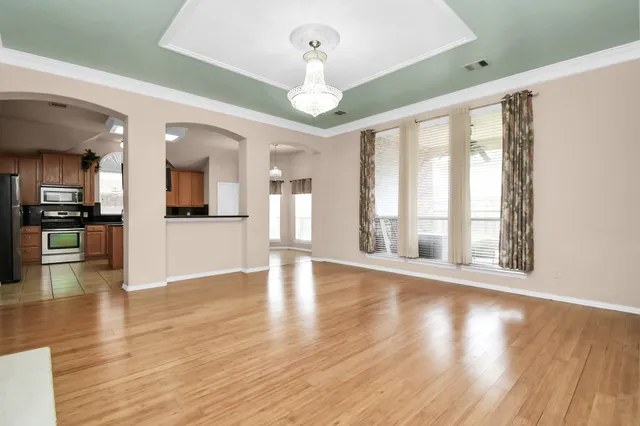 a view of an entryway with wooden floor and a kitchen