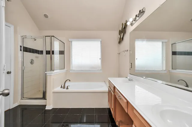 a bathroom with a tub sink and mirror