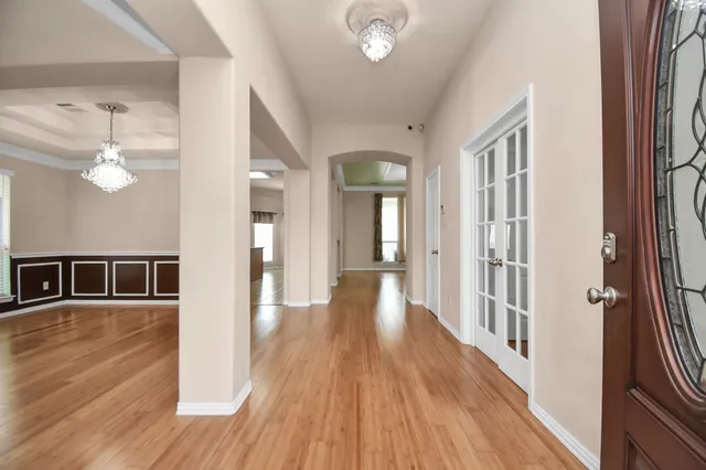 a view of a hallway with wooden floor and dining room