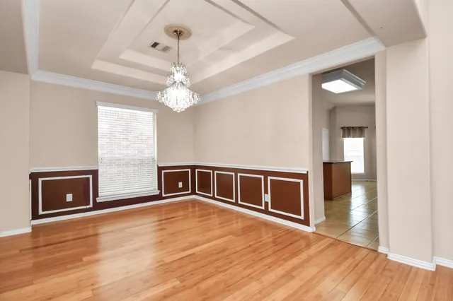 a big room with wooden floor fireplace and windows
