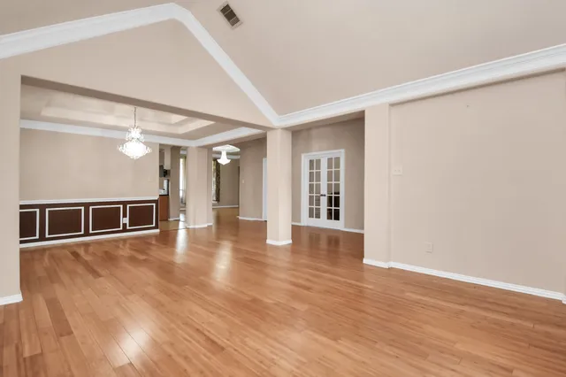 a view of a big room with wooden floor and windows