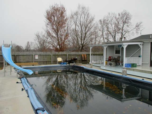 a view of a swimming pool with two chairs in a balcony