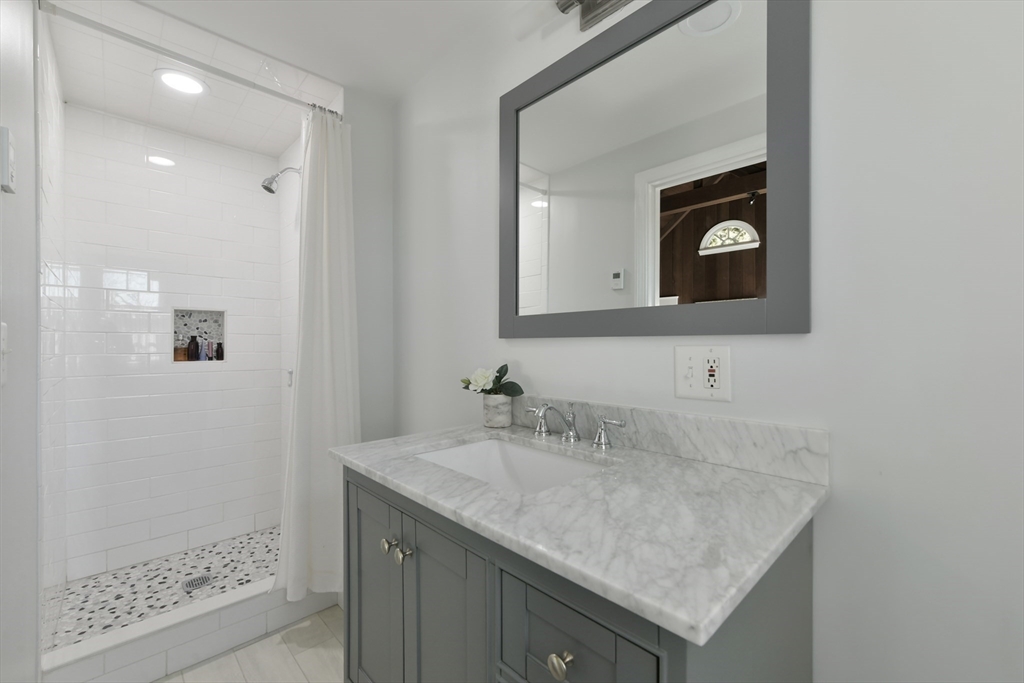 17 Laurel Road Brookline, MA 02467 - Photo 14 of 29 a bathroom with a granite countertop sink and a mirror