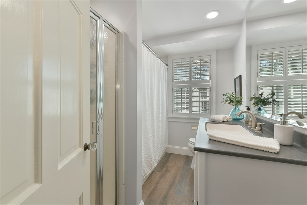 17 Laurel Road Brookline, MA 02467 - Photo 16 of 29 a bathroom with a sink a mirror and a shower