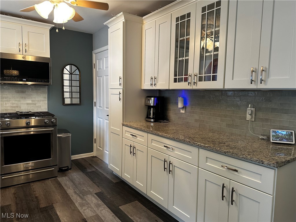 739 Sterling Road Wickliffe, OH 44092 - Photo 2 of 27 Kitchen featuring dark hardwood / wood-style floors, appliances with stainless steel finishes, decorative backsplash, white cabinetry, and ceiling fan